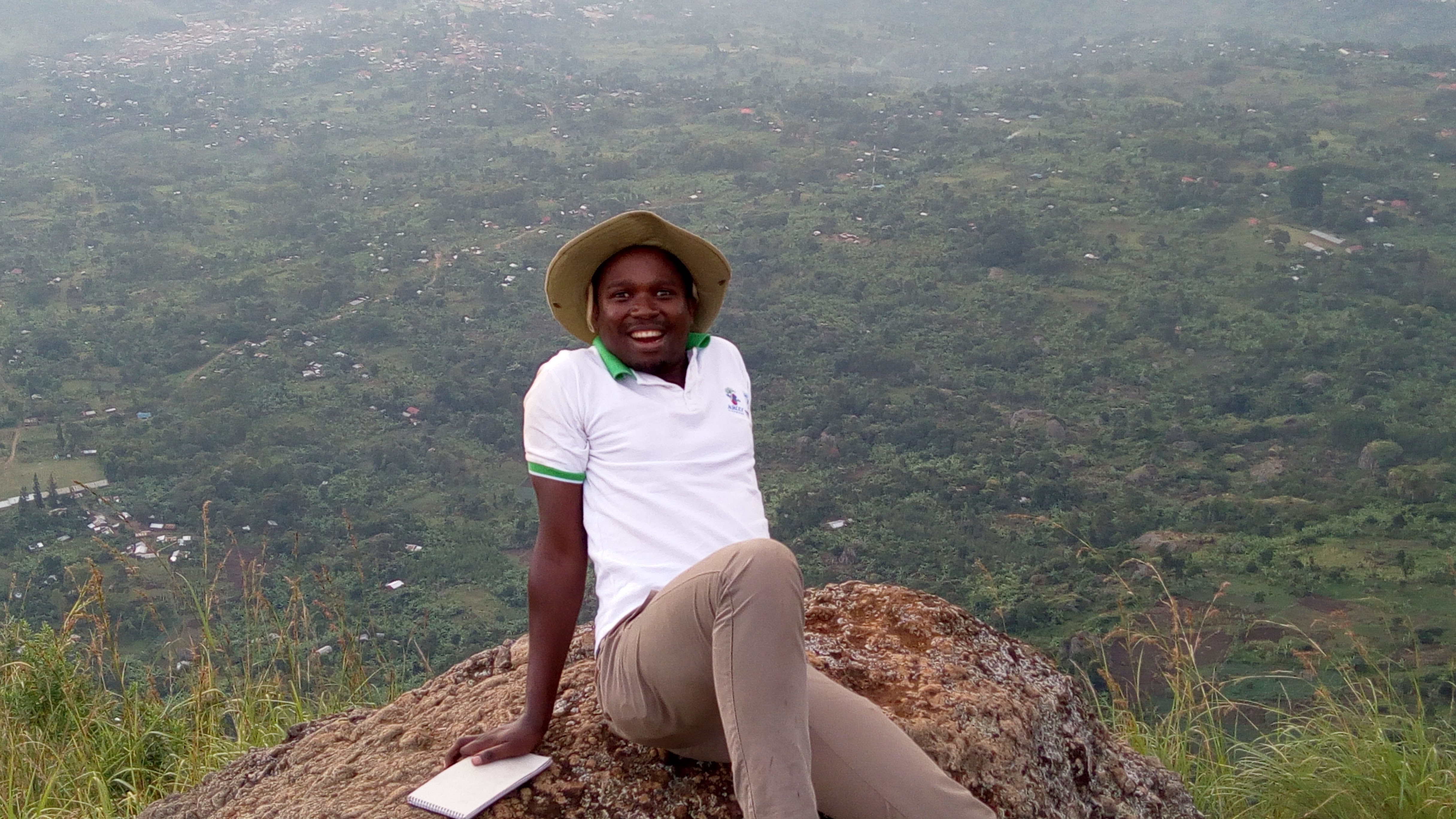 Faustin Gashakamba smiling in a mountain landscape